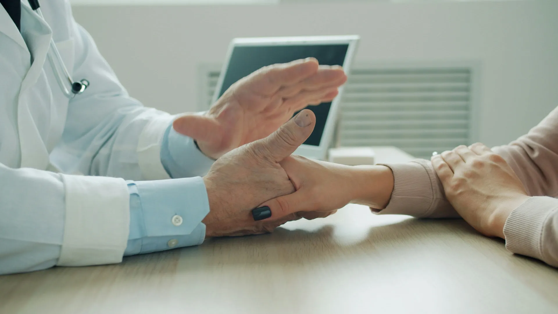 Médico sosteniendo la mano de un paciente
